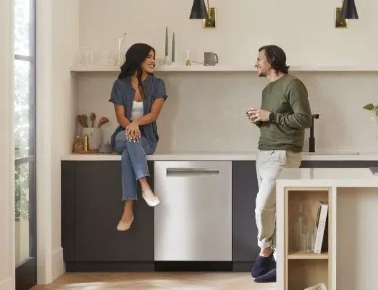 two people talking next to a dishwasher